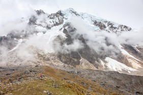 A hiker marvels at the immense size of Salkantay mountain at Salkantay Pass (4800m), near Mollepata, Peru, South America