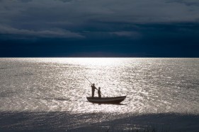Boys in a small boat on Lake Titicaca, Llachon, Capachica Peninsula, Puno, Peru, South America