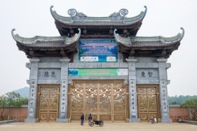Two people looking up at Bai Dinh Temple (Chua Bai Dinh) gate, Gia Vien District, Ninh Binh Province, Vietnam