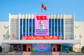 Ho Chi Minh portrait and Vietnamese flag with Happy New Year's sign (Chúc Mừng Năm Mới) on government building, Huế, Thừa Thiên-Huế Province, Vietnam