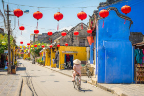 A Vietnamese woman rides a bicycle on the street in Hoi An Ancient Town, Hoi An, Quang Nam Province, Vietnam