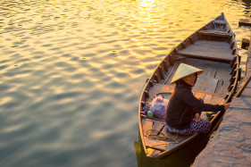Vietnamese woman in a boat on the Thu Bồn River at sunset, Hoi An, Quang Nam Province, Vietnam