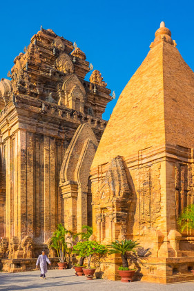A temple attendant walks past the Po Nagar temple Cham towers, Nha Trang, Khánh Hòa Province, Vietnam