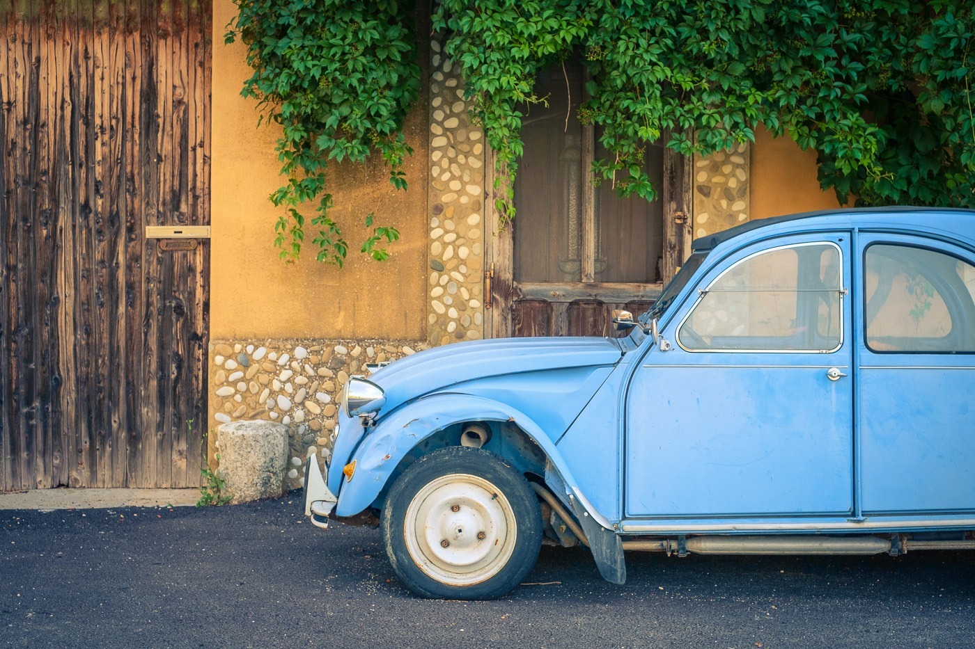 Vintage blue Citroën 2cv parked in front of a house