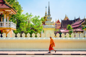 A buddhist monk walks past Wat Si Saket (Wat Sisaket) temple in central Vientiane, Laos